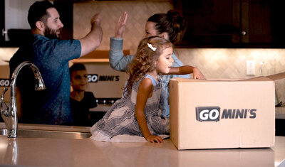 A happy family in a kitchen with Go Mini's boxes on the counters